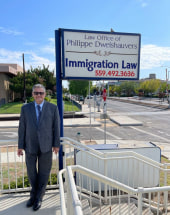 Philippe Dwelshauvers standing next to his firm's office sign